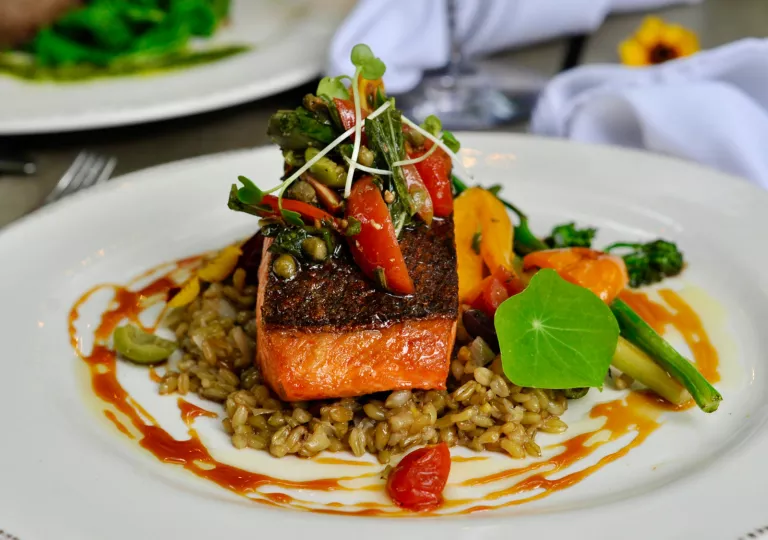 Plate of grilled fish on top of rice