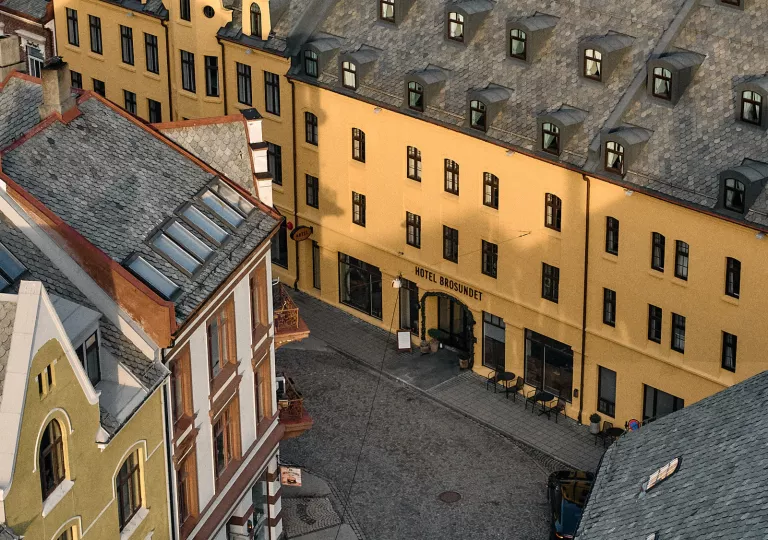 Exterior, sky view of an orange and black hotel building in the middle of a town center