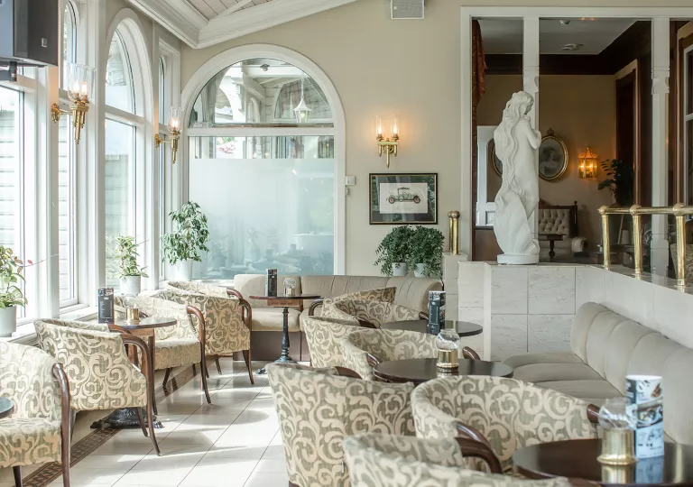 Indoor lounge and dining table with cushioned chairs and ceramic statues