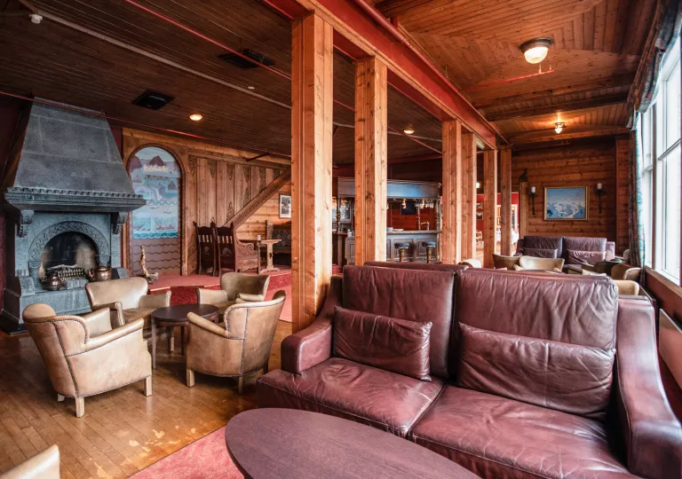 Cabin room with wooden pillars and leather couches