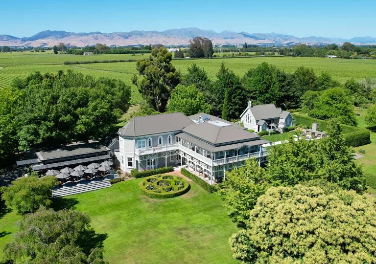 Exterior sky view of white hotel building in the middle of a grassy field