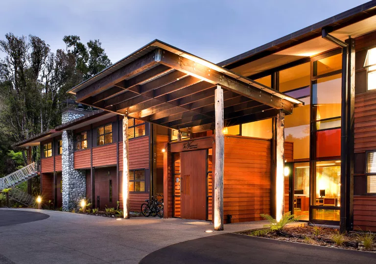 Exterior view of wooden hotel building with a tall wooden covering illuminated by lights