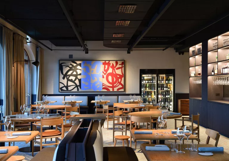Dining area and lounge with circular dining tables and wooden chairs