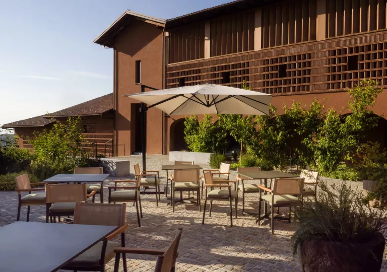 Outdoor dining area with cushioned chairs and square dining tables