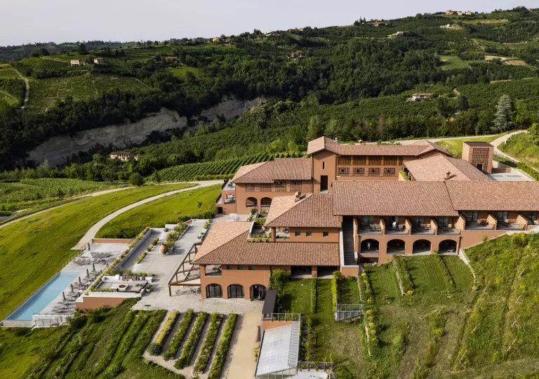 Sky view of brown hotel building with a large grass valley surrounding