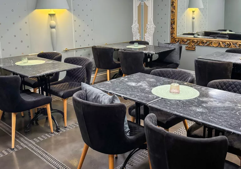 Dining hall with black tables and black cushioned chairs