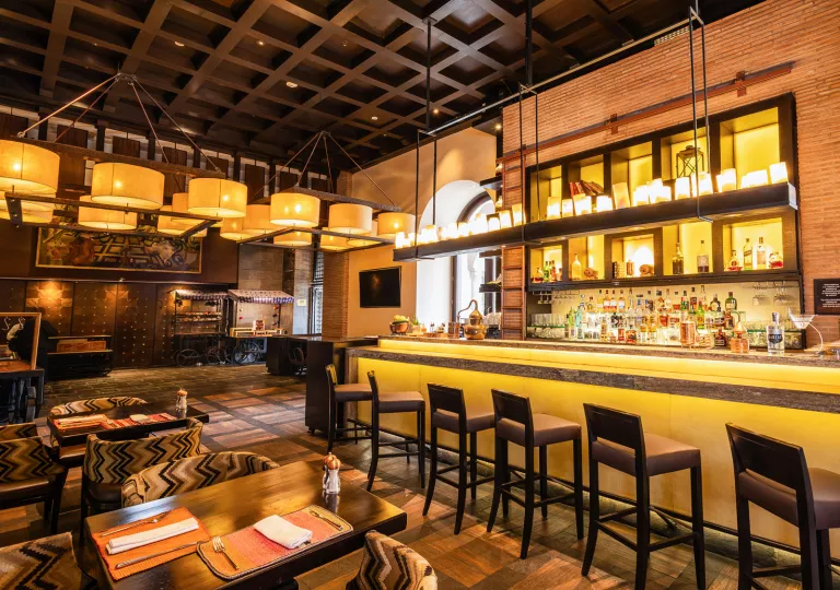 Bar and lounge with illuminated bar counters and large wooden stools