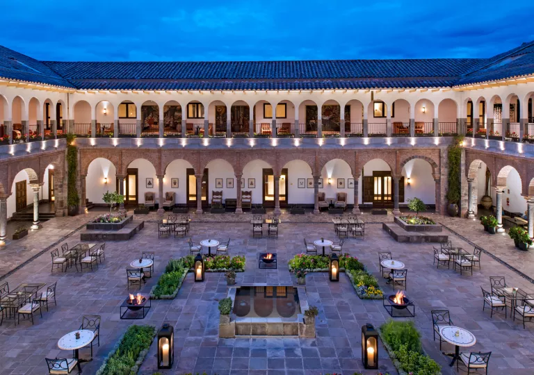 Outdoor view of a patio with stone flooring and circular dining tables