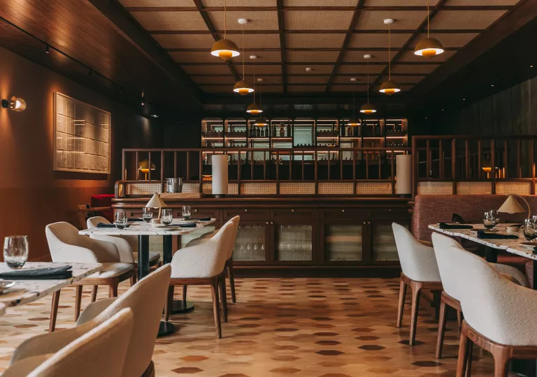 Restaurant dining room with cushioned chairs and marble tables