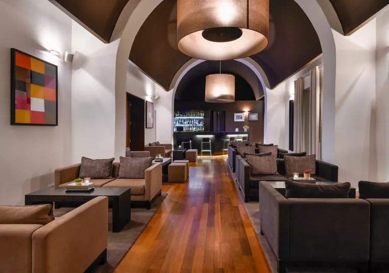 Long hallways with cushioned sofas and a bar at the end of the hallway