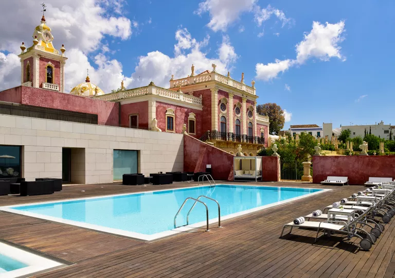 Outdoor pool with a red hotel building in the background