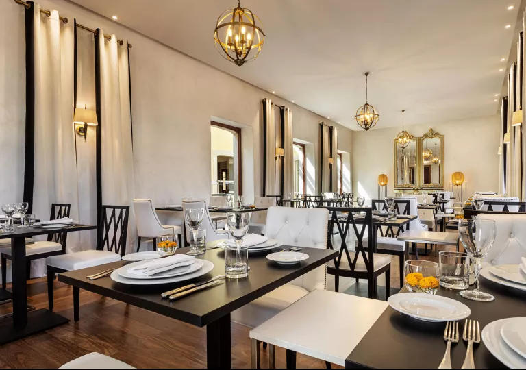 Restaurant with square black tables with white plates