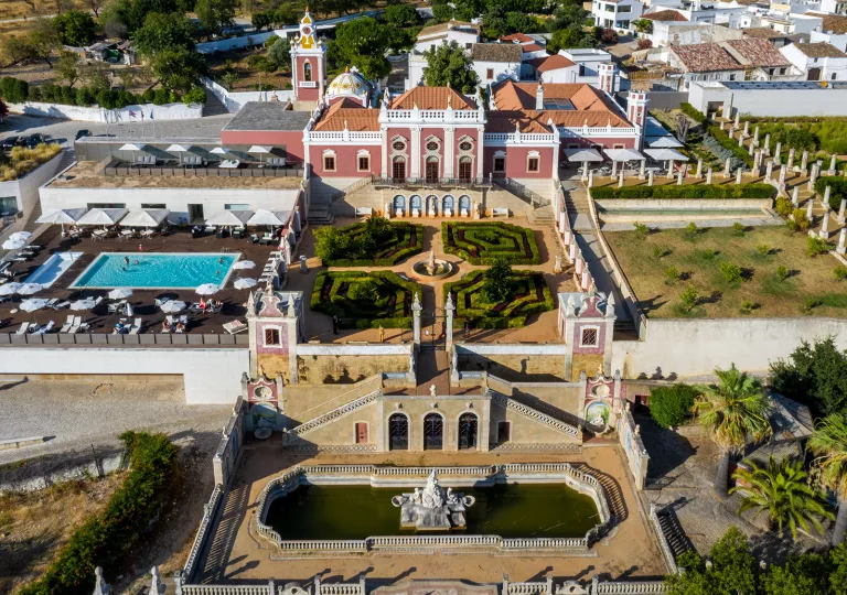 Sky view of hotel building with an outdoor garden and pool