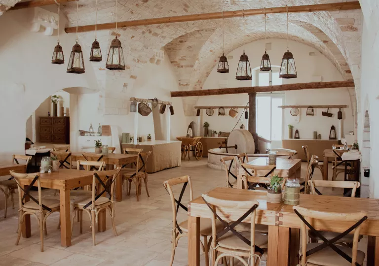 Indoor dining area with wooden chairs and tables with large wooden pillars in the back
