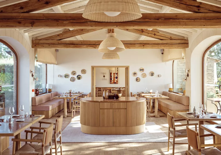 Dining table with cushioned sofas and wooden pillars