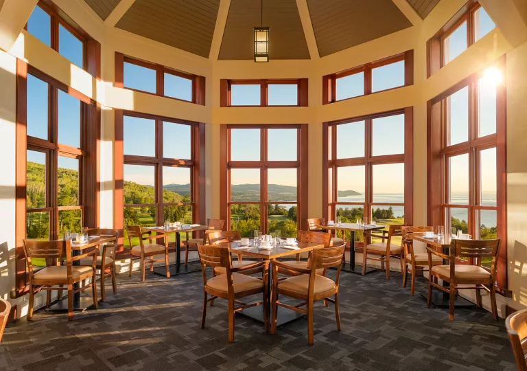 Dome-shaped room with large windows and dining tables with wooden chairs