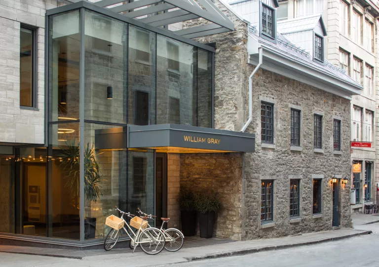 Exterior view of stone hotel building with a gray "Willian Gray" sign