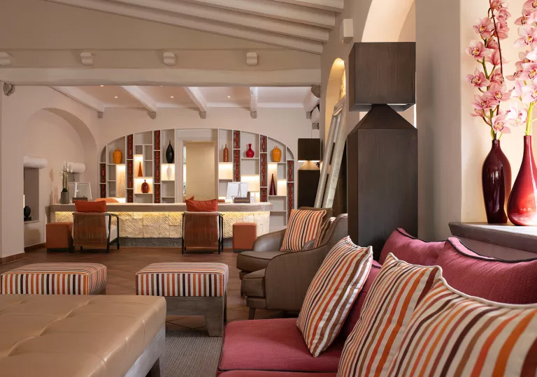 Lounge and seating area with cushioned chairs and a counter in the background