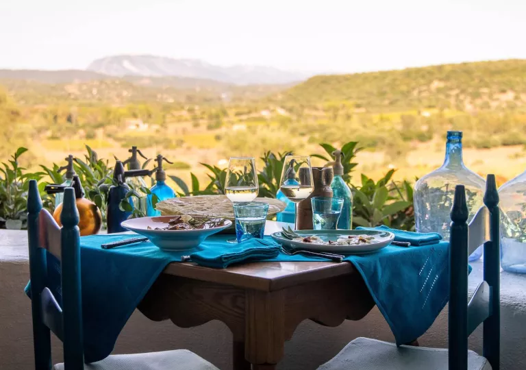 Outdoor dining table with blue cloths and wine glasses