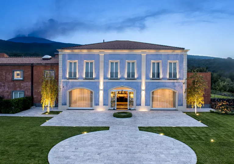 Exterior view of blue building with a large grass area in front