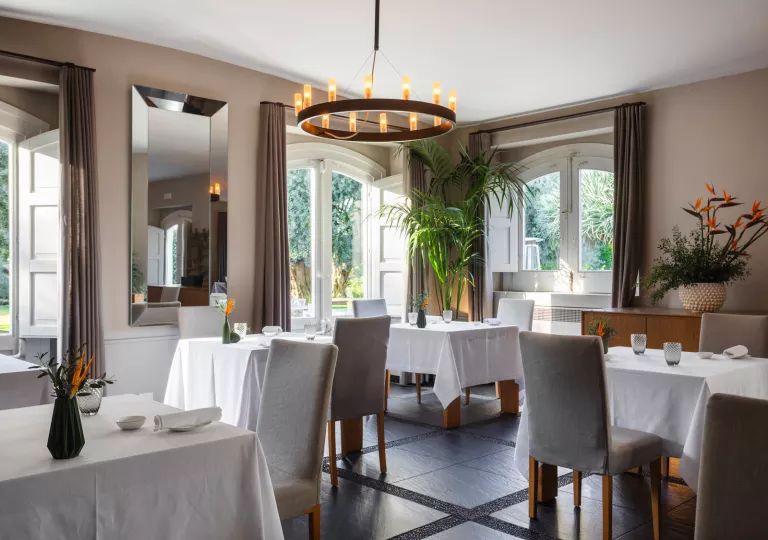Indoor restaurant dining hall with gray chairs and white tables