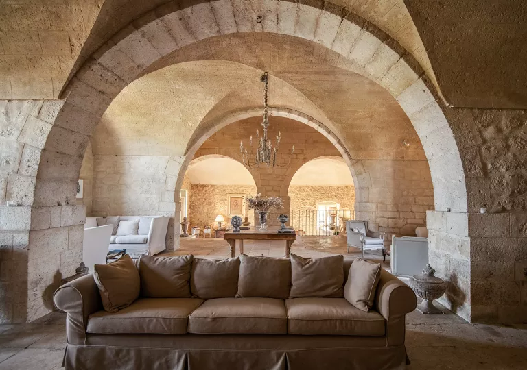 Indoor lobby and seating area with large, stone arches and large candle-light fixtures
