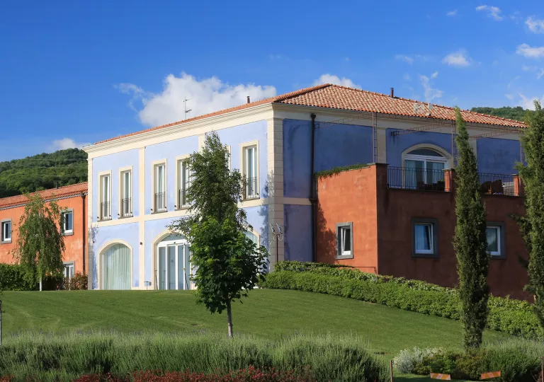 Exterior view of blue and orange buildings with a grass area in front