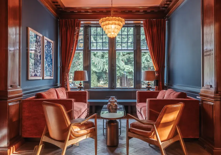 Seating area with cushioned, red sofas with large windows in the background