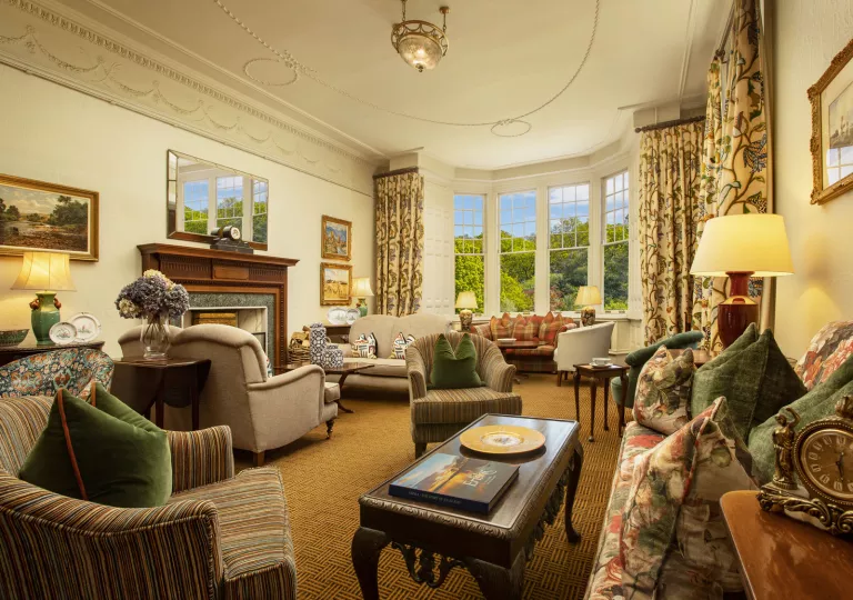 Lounge and seating area with cushioned chairs and large curtains in front of the windows