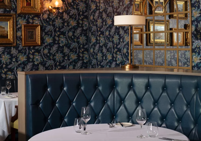 Dining table with dark blue sofa and wine glasses on the table