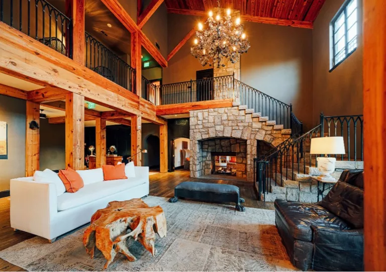 Wood cabin with large couch in front of fireplace
