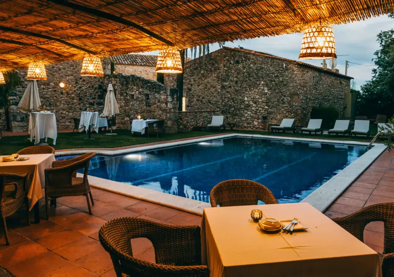 Outdoor pool with dining tables surrounding the area