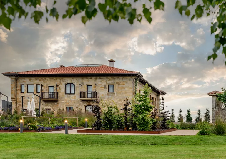 Exterior view of brick hotel building with grass field in front