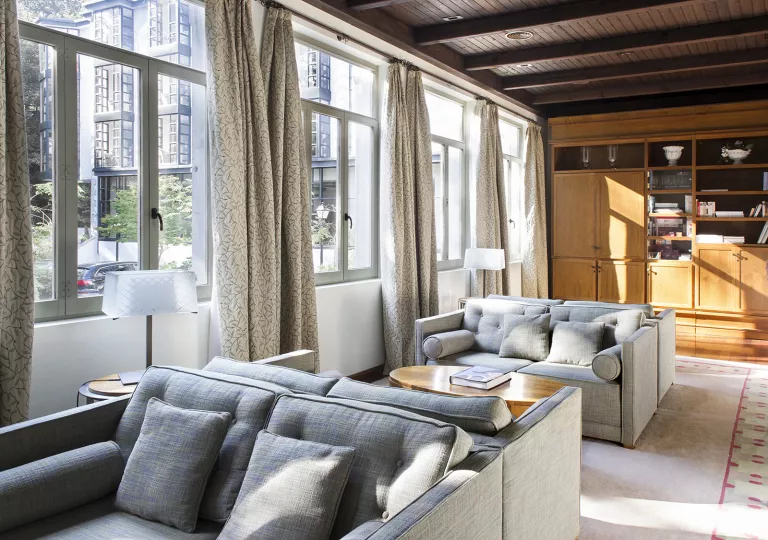 Seating area with gray, cushioned chairs and large windows