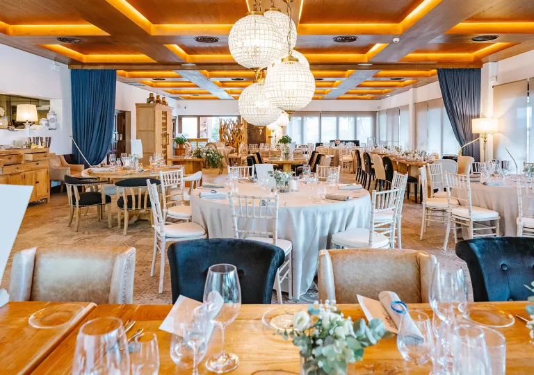 Indoor dining hall with circular dining tables and long, rectangular tables