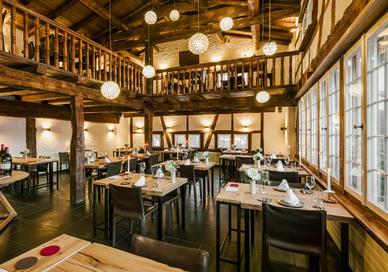 Two-story dining area with tables and black chairs