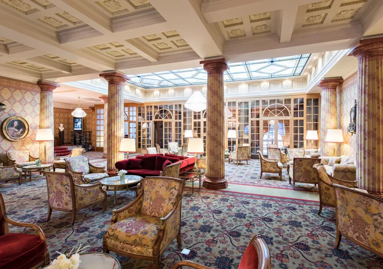 Indoor lobby and lounge with cushioned chairs and giant stone pillars