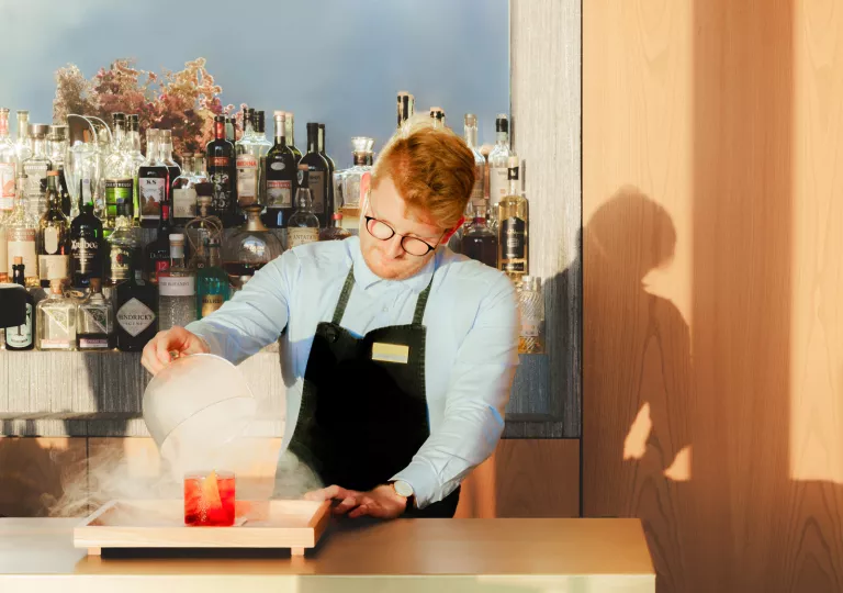 Bartender making a drink with fog in a glass