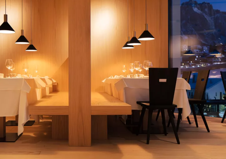 Restaurant dining area with two large tables and a wooden bench