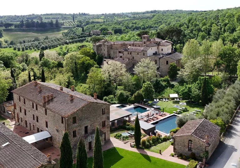 Sky view of stone hotel buildings with outdoor pools in front