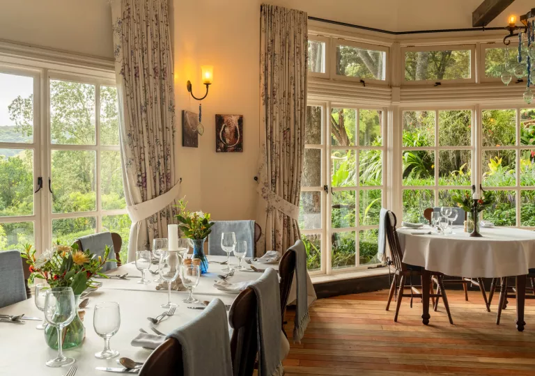 Restaurant dining hall with white dining tables and wooden chairs