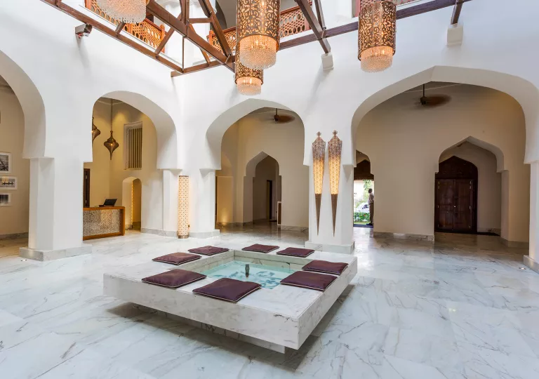 Large building foyer with a mini fountain in the center and large archways surrounding