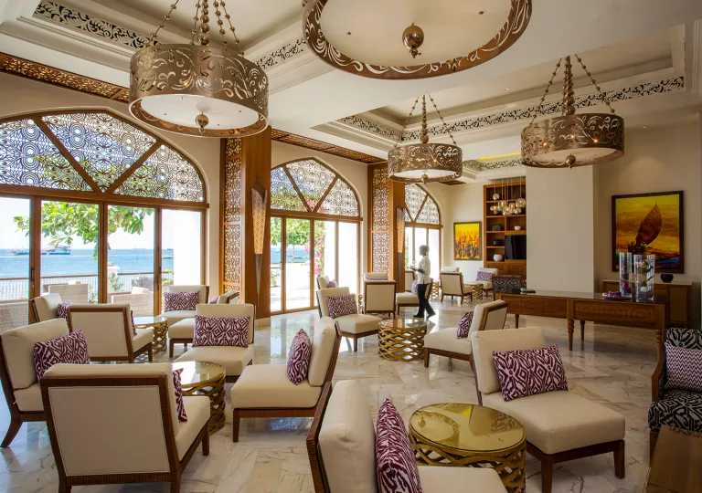 Hotel lobby with cushioned chairs surrounding circular coffee tables