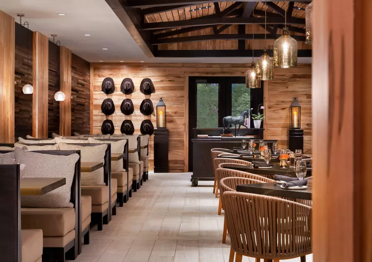 Indoor dining area in a lodge with cowboy hats hanging on the wall