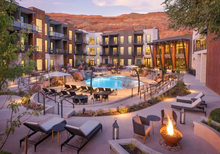 Exterior view of hotel building with balconies looking towards and outdoor pool