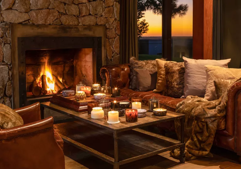 Cozy room with couches and a coffee table in front of a stone fireplace