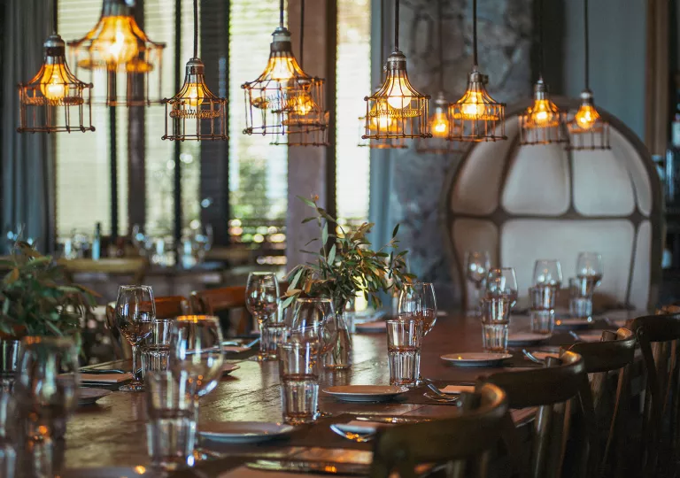 Dining hall with a large wooden dining table and glasses of water