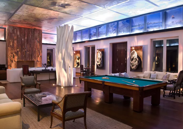 Lounge room with a billiards tables and couches along the room