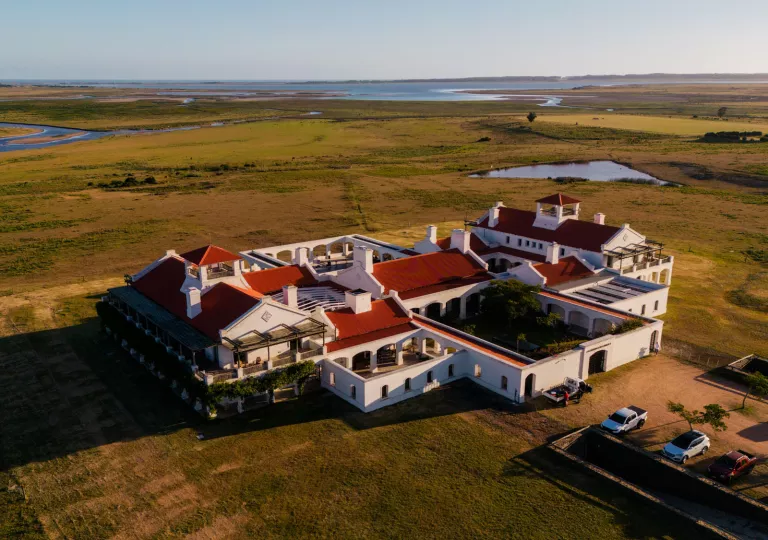 Sky view of white and red hotel building in the middle of a large valley