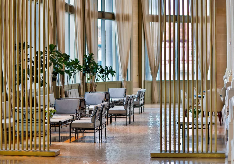 Lounge and seating area with beige couches and a wooden room separator